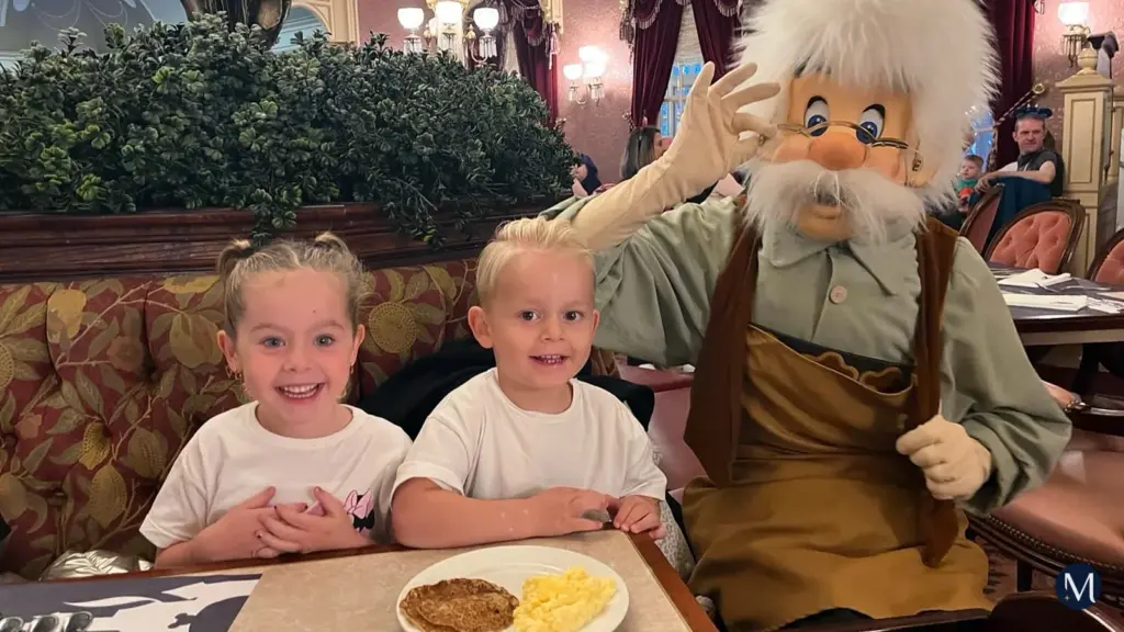 Twee kinderen aan het ontbijt in Plaza Gardens, met Geppetto naast hun tafel